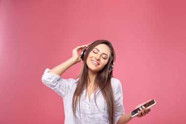 Kadın bir akıllı telefondan kulaklıklarla kablosuz müzik dinleme