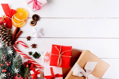 Beyaz arka planda harika bir Noel kompozisyonu. Altın Noel hediye kutuları, karlı köknar dalları, kozalaklı kozalaklar, tatil süslemeleri. Üst görünüm