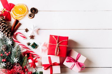 Beyaz arka planda harika bir Noel kompozisyonu. Altın Noel hediye kutuları, karlı köknar dalları, kozalaklı kozalaklar, tatil süslemeleri. Üst görünüm