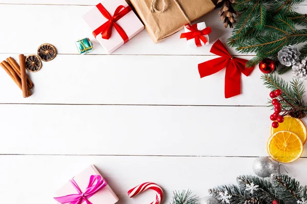 Prachtige Kerstcompositie Houten Witte Achtergrond Kerstdozen Besneeuwde Dennentakken Naaldbomen Karamelstokje — Stockfoto