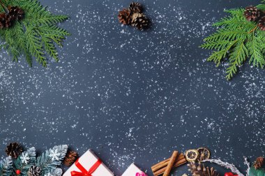 Noel arkaplanı köknar ağacı, Noel hediye kutuları, karlı köknar dalları, kozalaklı kozalaklar, koyu arkaplanda hediye. Üst Manzara. Uzayı kopyala Yeni yıl. Dekorasyon