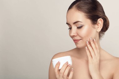 Temiz Taze Cilt dokunmatik kendi yüzüne sahip Güzel Genç Kadın. Kız tutma ve nemlendirici krem uygulayın. Yüz bakımı. Cilt bakımı. Kozmetoloji, güzellik ve spa.