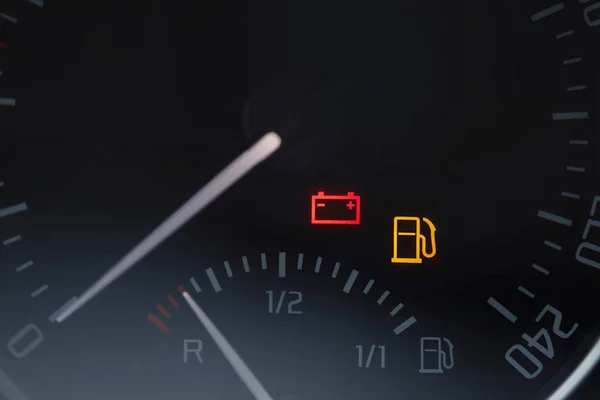 Close up shot of a car dashboard with the battery icon lit. Empty fuel ...