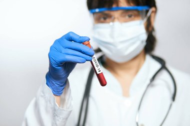 Doktor bilim adamı 2019 nCoV analizi için test tüpünü kanla tutuyor. Çin Koronavirüsü kan testi konsepti. Aşı araştırması.