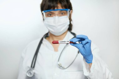 Doktor bilim adamı 2019 nCoV analizi için test tüpünü kanla tutuyor. Çin Koronavirüsü kan testi konsepti. Aşı araştırması.