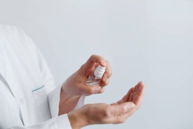Mikrop, bakteri ve virüs yayılmasını önlemek için alkol spreyi ya da anti bakteri spreyi kullanan bir kadının eli. Kişisel hijyen kavramı. 