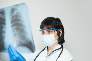 Hastanedeki klinikte bulunan Covid-19 hastasının viral zatürresi için akciğerlerinin röntgenlerini inceleyen bir tıp doktoru. Coronavirus konsepti 