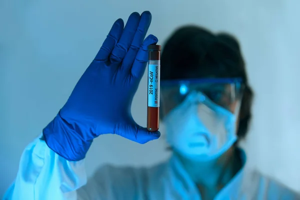 Coronavirus 2019-nCoV Blood Sample. New Epidemic Corona Virus. Corona virus outbreaking. Corona Virus in Lab. Scientist in protective gloves, mask and glasses  hold tube with Blood Test