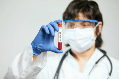 Doktor bilim adamı 2019 nCoV analizi için test tüpünü kanla tutuyor. Roman Coronavirus kan testi konsepti. Aşı araştırması.