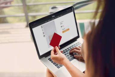 Kadının elinde kredi kartı ve dizüstü bilgisayar var. Concept Alışveriş Çevrimiçi Teknoloji. Evden çalışmak 