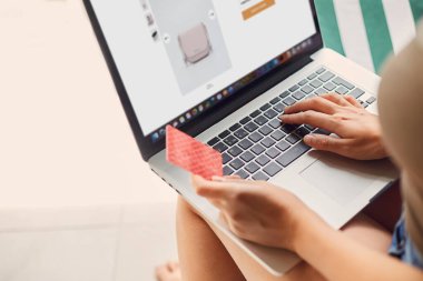 Kadının elinde kredi kartı ve dizüstü bilgisayar var. Concept Alışveriş Çevrimiçi Teknoloji. Evden çalışmak 