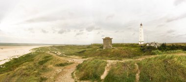 Lighthouse and bunker in the sand dunes on the beach of Blavand, Jutland Denmark Europe clipart