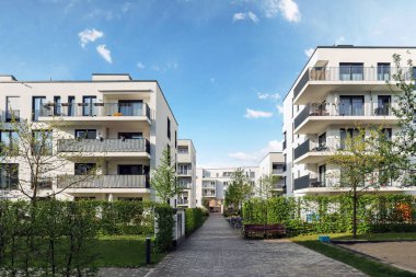 Modern apartman binaları ve şehirde yeni yeşil şehir manzarası olan bir yerleşim yeri.