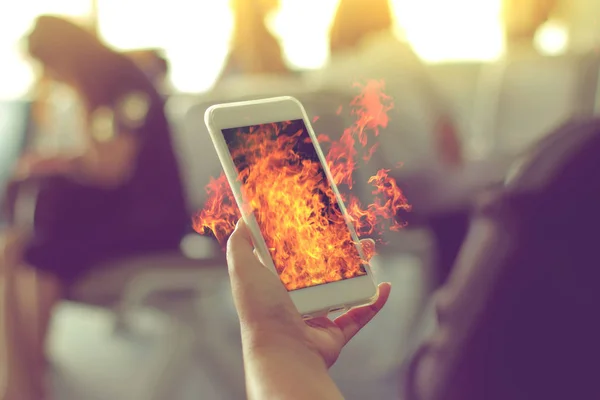 Woman hand Using a Smart Phone with flame fire as hot, hot new