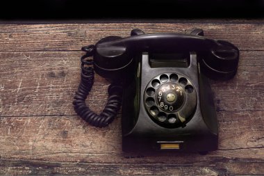 Vintage eski siyah döner telefon ile toz ve çizikler ahşap