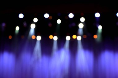 Mor perdeler ve sahne ışıkları ile bulanık tiyatro sahne.