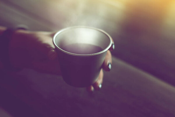 black coffee is served hot in stainless steel cup on wood table 