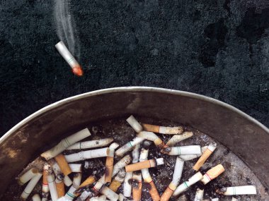 yanan sigara kül tablası koyu arka plan üzerine atma. 