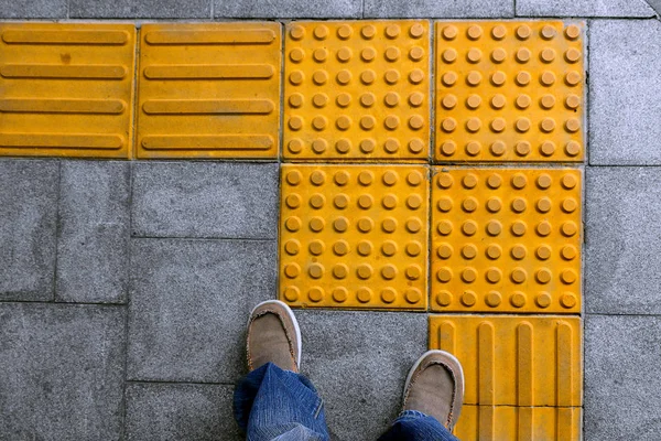 Shoes on block tactile paving for blind handicap. — Stock Photo, Image