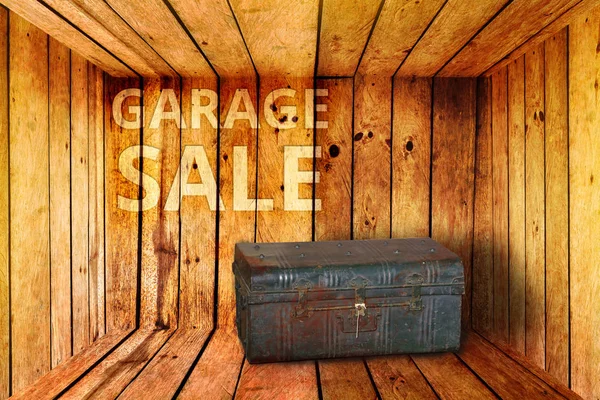 old iron box and garage sale words background in wooden room