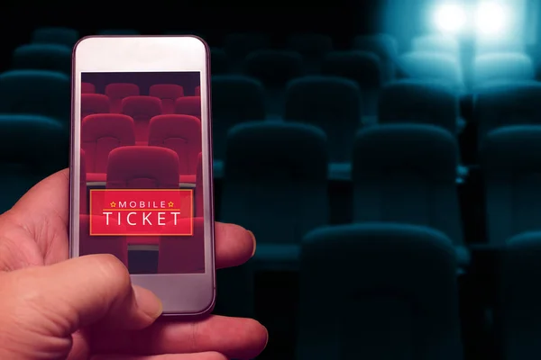 Smartphone için ayrılmış sinema bileti tutan el. Online bilet satın alma.