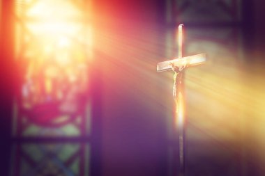 Çarmıha gerilmiş İsa, kilisede, boyalı camdan gelen ışıkla.