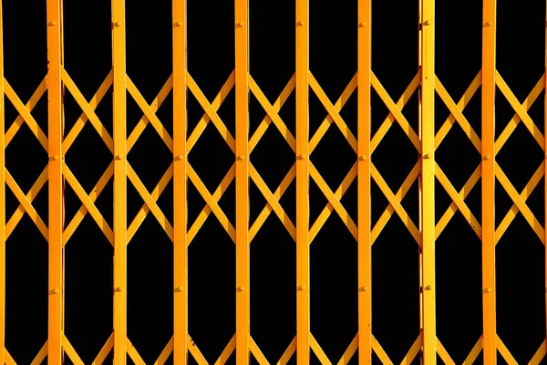 折り畳み式のゲートから黄色の幾何学模様 古代黄拡大黒い背景に金属製のドア — ストック写真