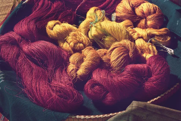 Zbliżenia barwy czerwonej i żółtej jedwabnej przędzy do tkania, tajskiej tkaniny błotnej, przędzy jedwabnej barwionej z materiałów naturalnych — Zdjęcie stockowe