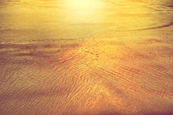 Reflectie van gouden kleur zeegolf op zand bij zonsondergang licht op het strand — Stockfoto