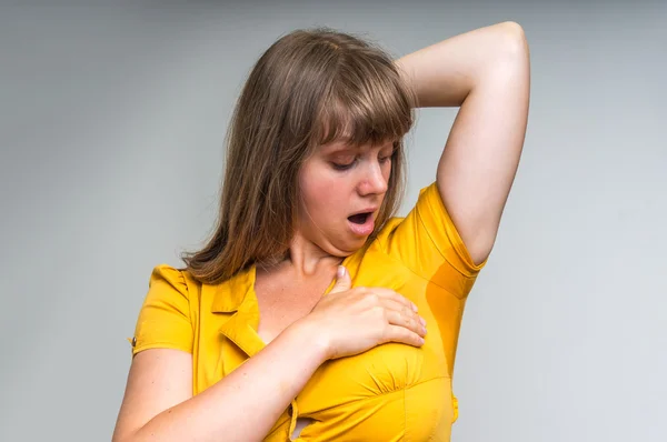 Mulher com sudorese sob axila em vestido amarelo — Fotografia de Stock