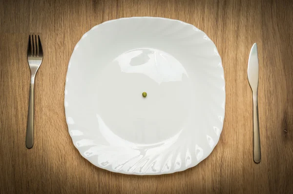 One green pea on white plate — Stock Photo, Image