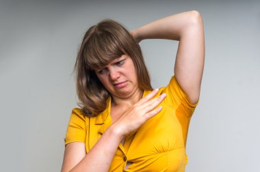 Woman with sweating under armpit in yellow dress clipart