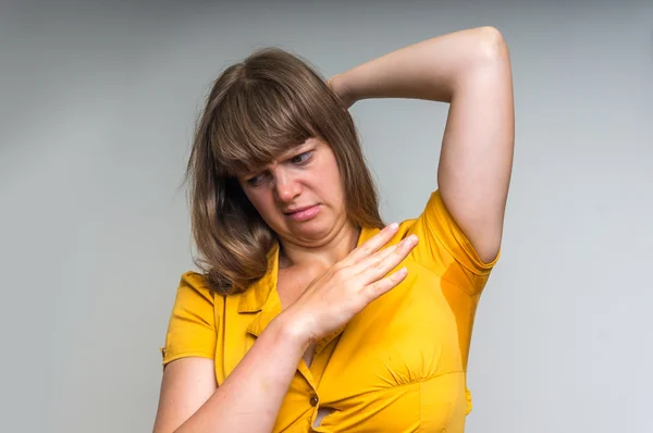 Mulher com sudorese sob axila em vestido amarelo — Fotografia de Stock