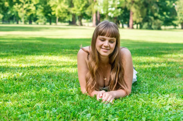 Joven bonita mujer acostada en la hierba — Foto de Stock