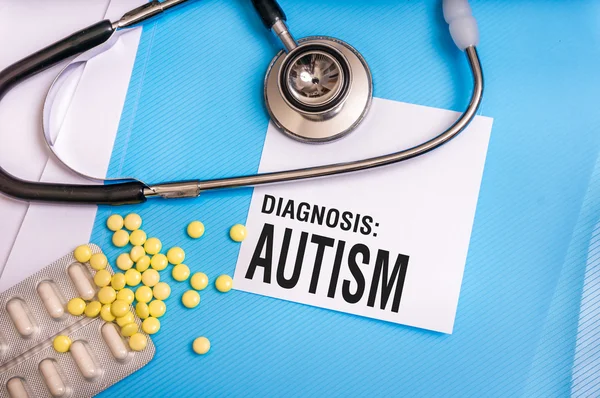 Слово аутизма написано на медицинской голубой папке с файлами пациентов — стоковое фото