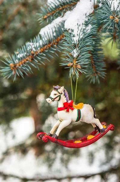 Rocking horse and snowy pine tree decorated for Christmas — Stock Photo, Image