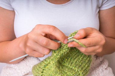 Kadın el ile yeşil yün örgü iğneleri ile