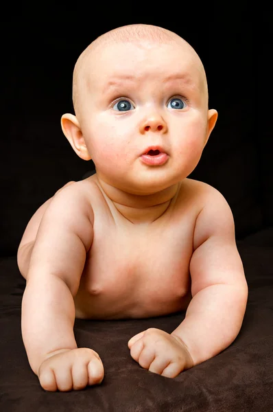 Счастливый и забавный новорожденный ребенок на черном — стоковое фото