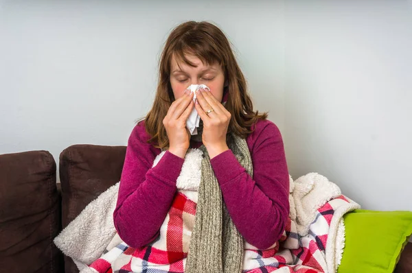 Mujer enferma teniendo gripe y sonándose la secreción nasal — Foto de Stock