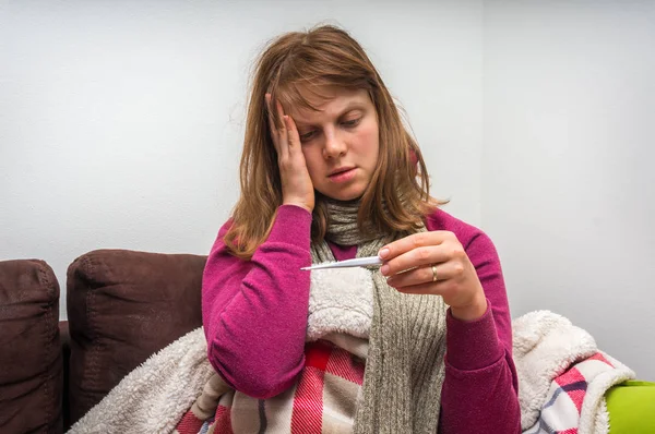 Mujer joven enferma con termómetro que tiene gripe y dolor de cabeza — Foto de Stock