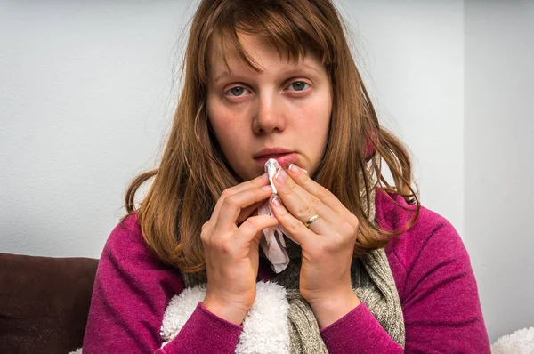 У больной женщины грипп и чихание в носовой платок — стоковое фото