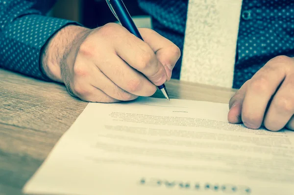 İşadamı bir anlaşma sonuçlandırmak için bir sözleşme imzalama