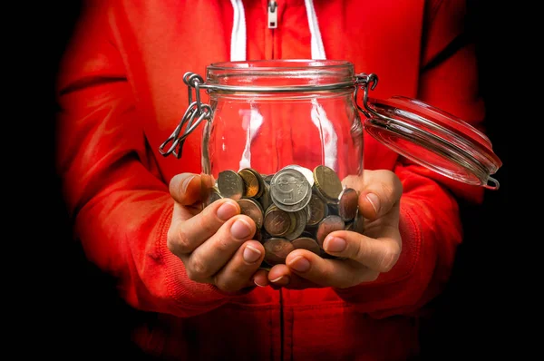 Mulher de camisola vermelha segurando frasco de dinheiro com moedas — Fotografia de Stock