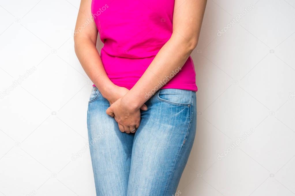 Woman with hands holding her crotch - incontinence concept