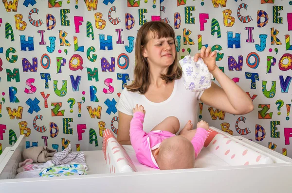 Mother changing smelly diaper to her little baby girl — Stock Photo, Image