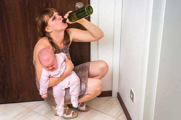 Bezohledné žena pití alkoholu a drží své dítě — Stock fotografie