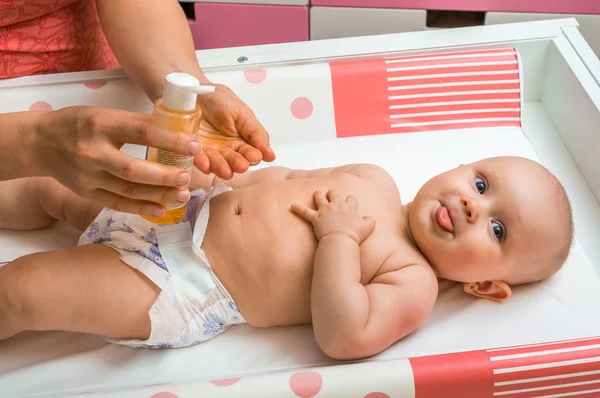 Mère fait un massage pour son bébé et applique de l'huile sur les mains — Photo