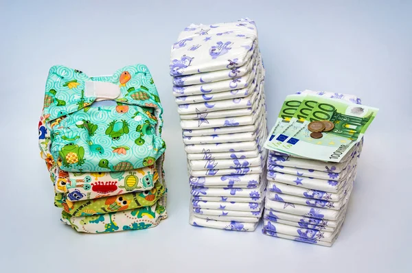 Compare reusable cloth diapers with pile of disposable diapers — Stock Photo, Image