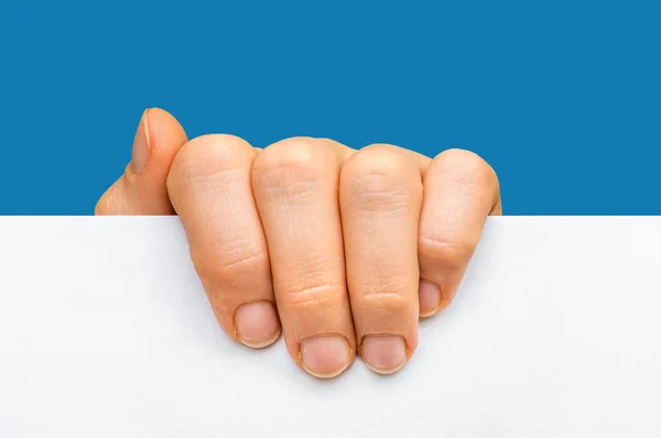Kvinnas hand hålla vitt blankt papper - isolerad på blå — Stockfoto