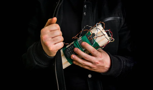 Dangerous terrorist in black jacket with dynamite bomb in hand — Stock Photo, Image